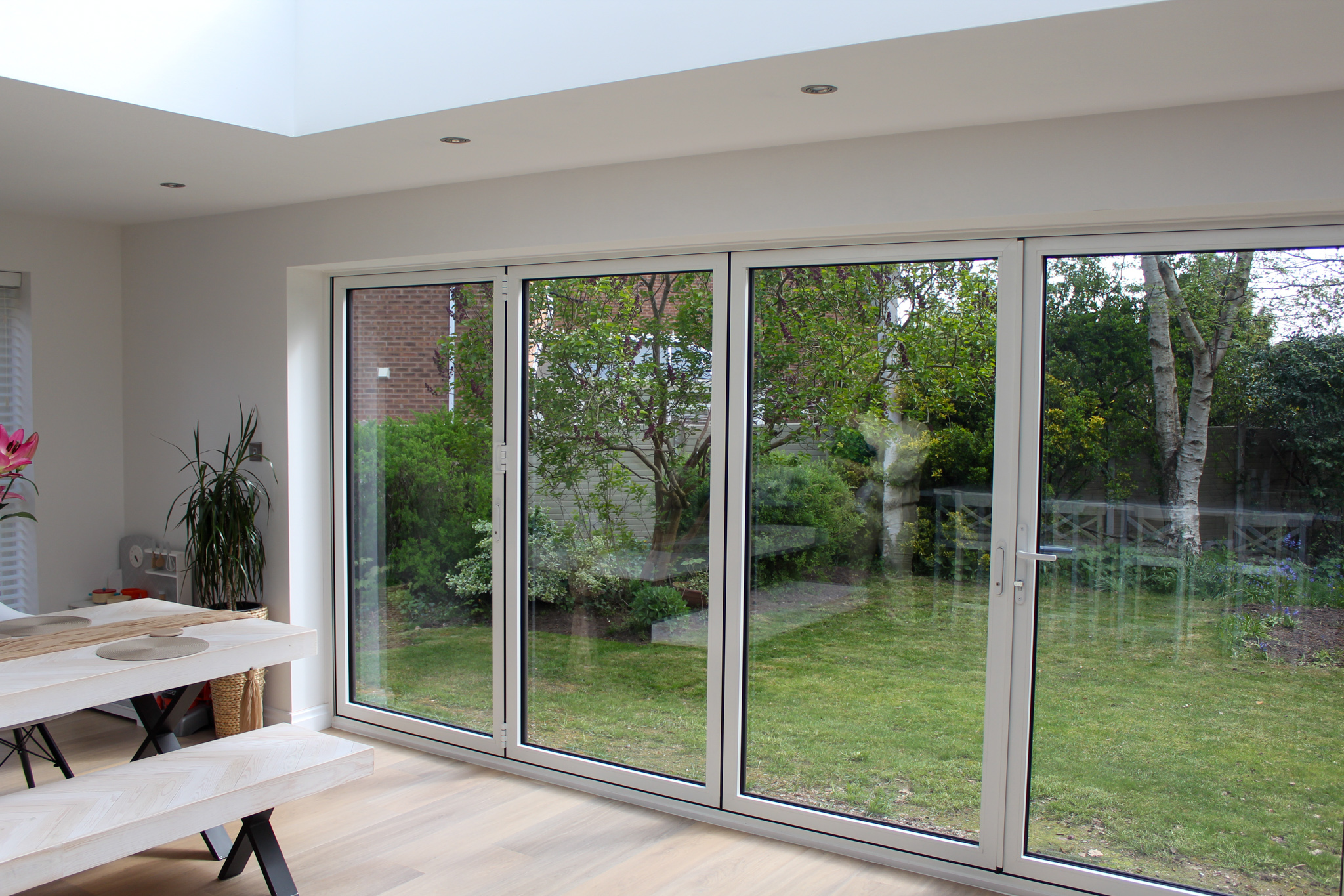 White-frame bifold doors interior view onto garden