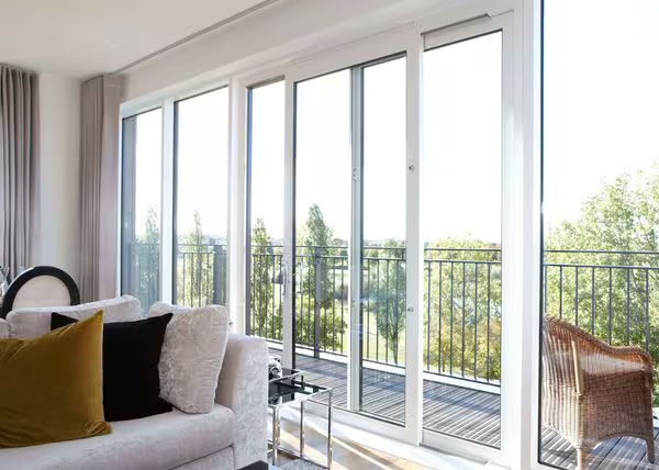 REHAU sliding doors opening from a modern living room onto a balcony