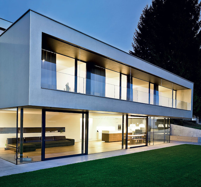 Contemporary home at dusk with slim-frame aluminium glazing across both floors