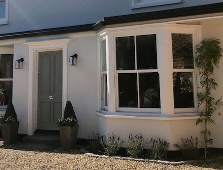 Heritage projecting bay window with sash glazing on a period white-painted property