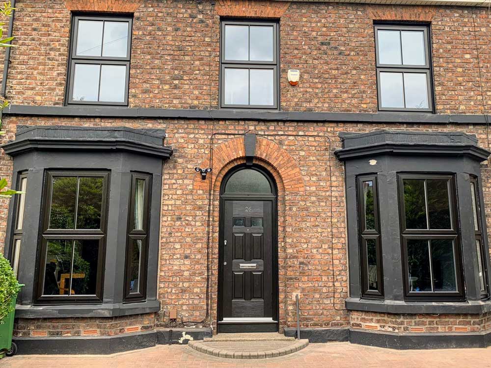 Black-frame projecting bay/oriel windows on a Liverpool brick terrace